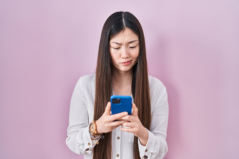A woman looking unsure while scheduling her first gynaecological visit